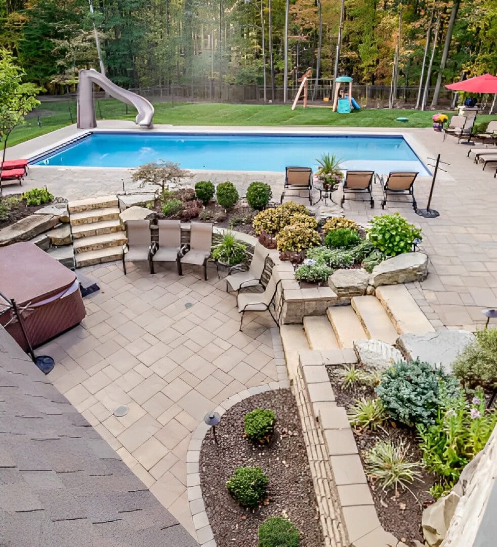 A backyard with an outdoor pool and patio furniture.